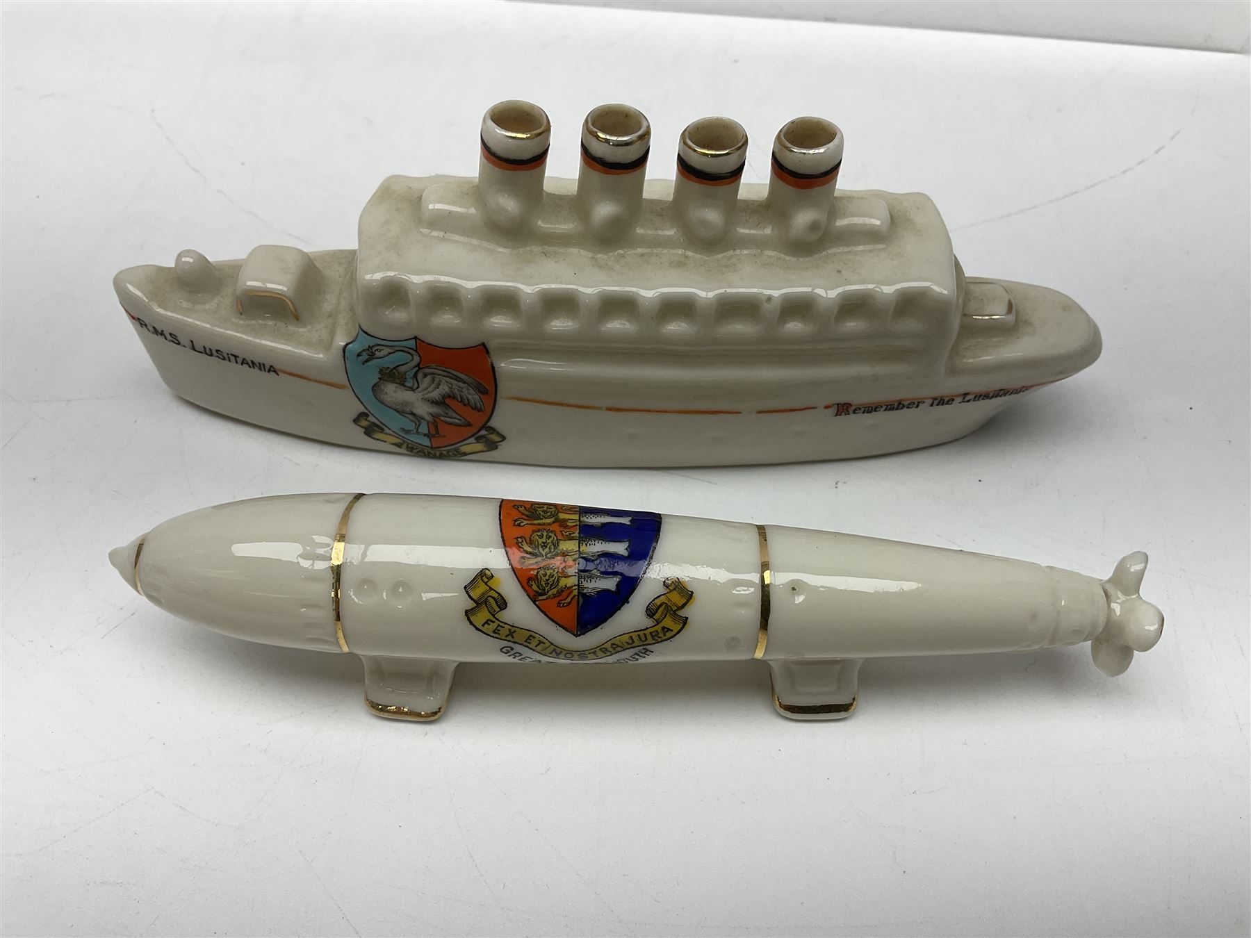 Ten WW1 crested china military models comprising submarine, four ships including Lusitania, four Zeppelins/balloons and an aircraft; various makers including Arcadian China, Swan China, Carlton China, Waterfall, Grafton China etc; various crests including Saint Neots, Great Yarmouth, Tewksbury, Swanage, Simons Town, Hull etc (10)