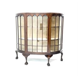 Early 20th century mahogany demi-lune display cabinet, single glazed door enclosing two lined shelves, ball and claw feet