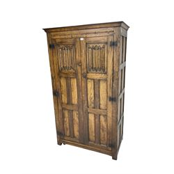 Mid-to-late 20th century oak double wardrobe, enclosed by panelled doors with linenfold decoration