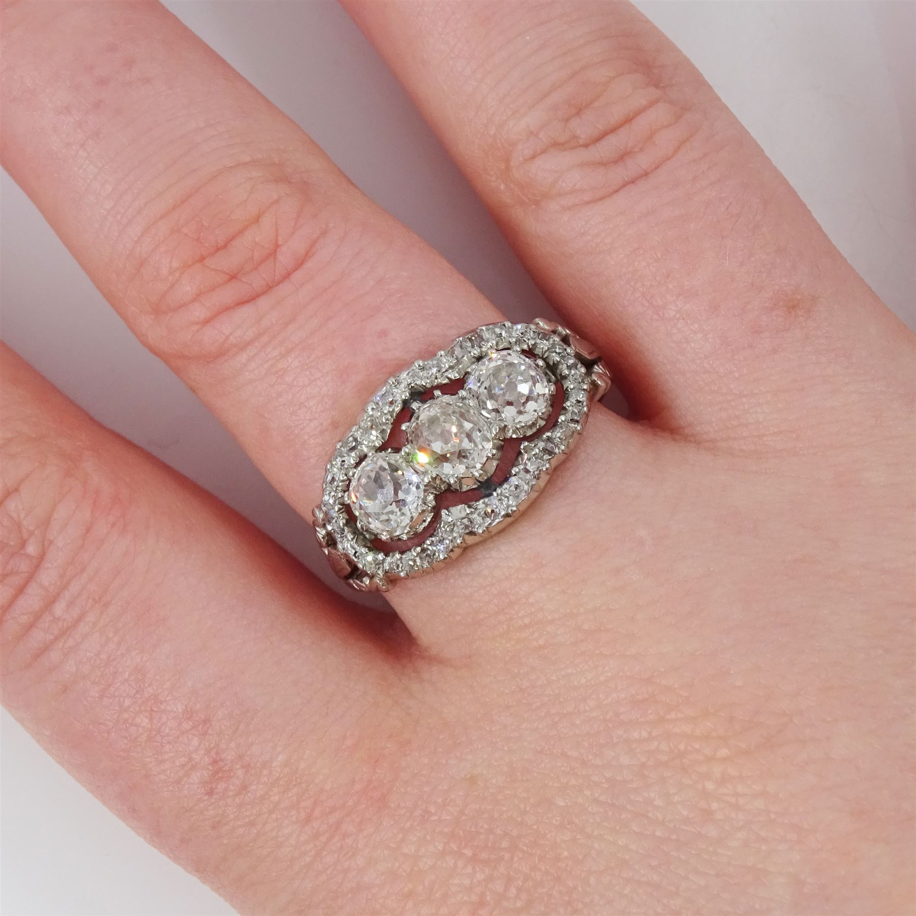 Late 19th / early 20th century platinum diamond ring, three old cut diamonds, in an openwork setting surrounded by further old cut diamonds, with pierced design shoulders, principal three diamonds total weight approx 1.45 carat, in a velvet and silk lined box by Selfridges