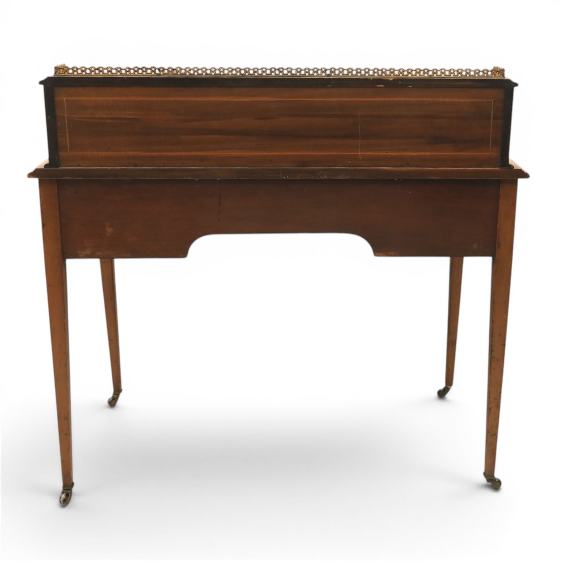 Maple & Co - Edwardian mahogany inlaid writing desk, the superstructure with pierced brass gallery, above an inset mirror and two short drawers, inset leather writing surface, bow fronted with crossbanded drawers and brass swan neck handles, square tapering supports terminating in castors 
