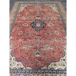 Persian Sarough carpet, red ground field with central medallion surround by trailing foliage and stylised flower heads, the multiple band border with scrolling designs