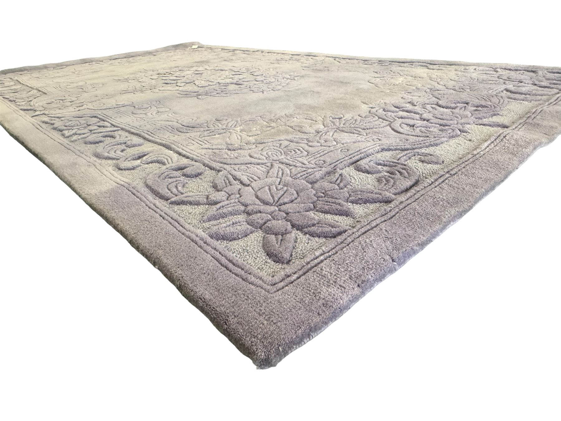 Chinese wool rug, purple ground with tonal floral and foliate pattern, central medallion of stylised flowers, the corners with large rosettes, framed by broad border of scrolling floral and leafy motifs 