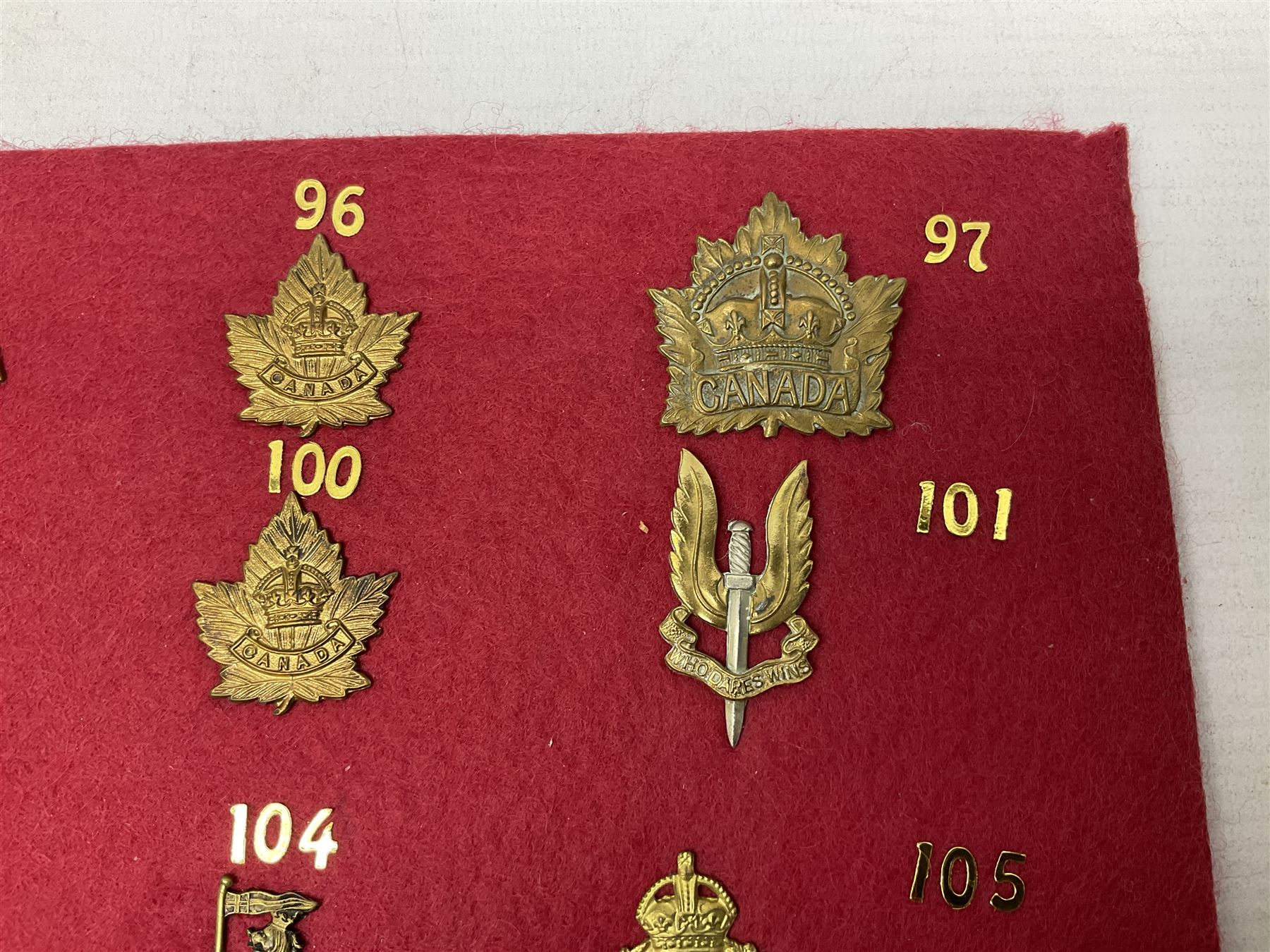 Forty glengarry and cap badges and shoulder titles including Gordon Highlanders, Canada and Canadian Field Artillery, New Zealand Field Artillery and Rifle Regiment, Shropshire Light Infantry, 14th/20th Kings Hussars, 17th Lancers, Northamptonshire Yeomanry, Royal Lincolnshire, Special Air Service, 19th Alexandra P.W.O. Hussars etc; mounted on two boards for display (2)
