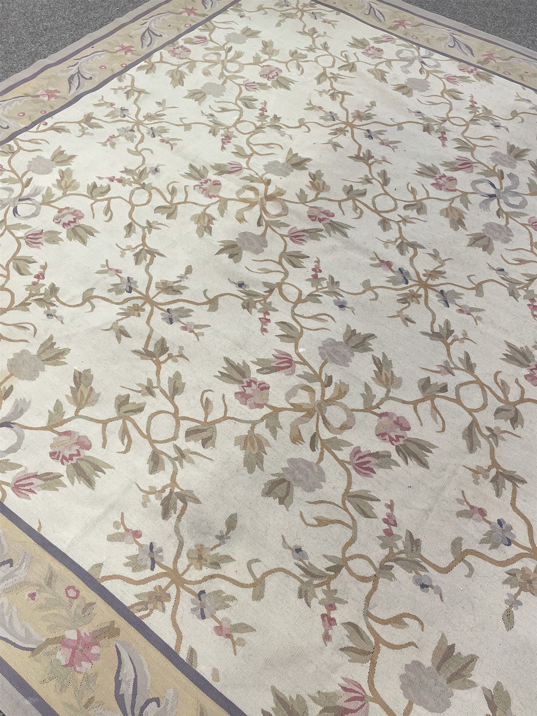 French style Aubusson rug, the pale ground field decorated with interlacing foliage and flower heads, repeating border 