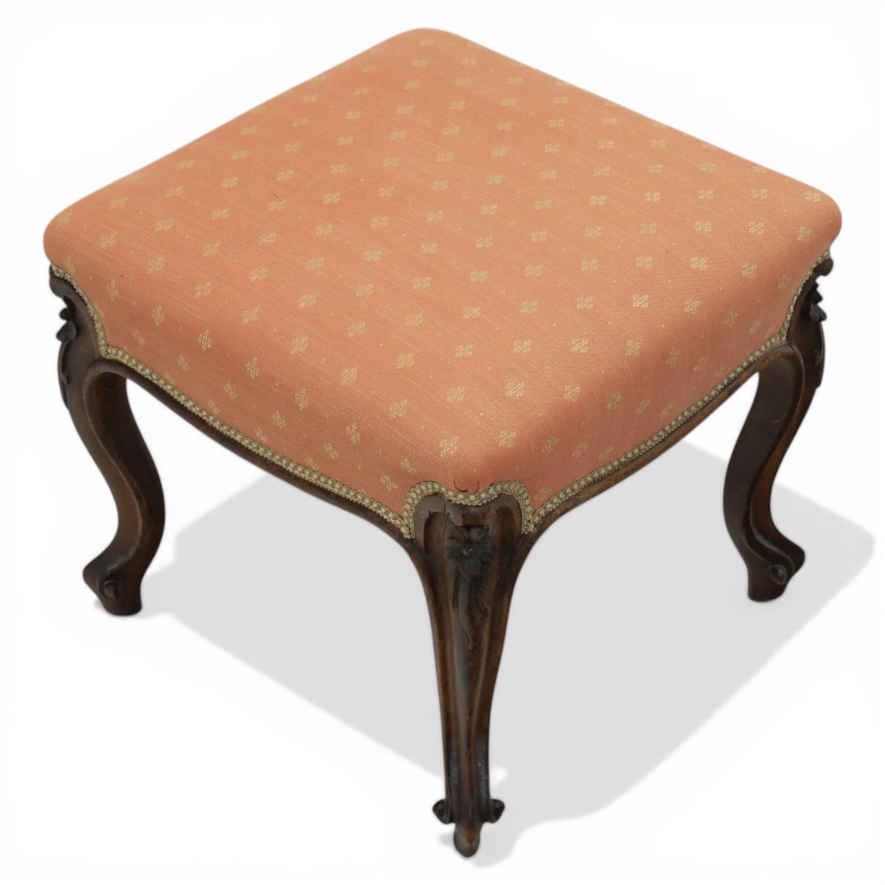 19th century mahogany framed footstool on floral carved cabriole supports upholstered in coral fabric