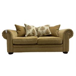 Contemporary two seat sofa bed, upholstered in textured champagne fabric, with contrasting scatter cushions