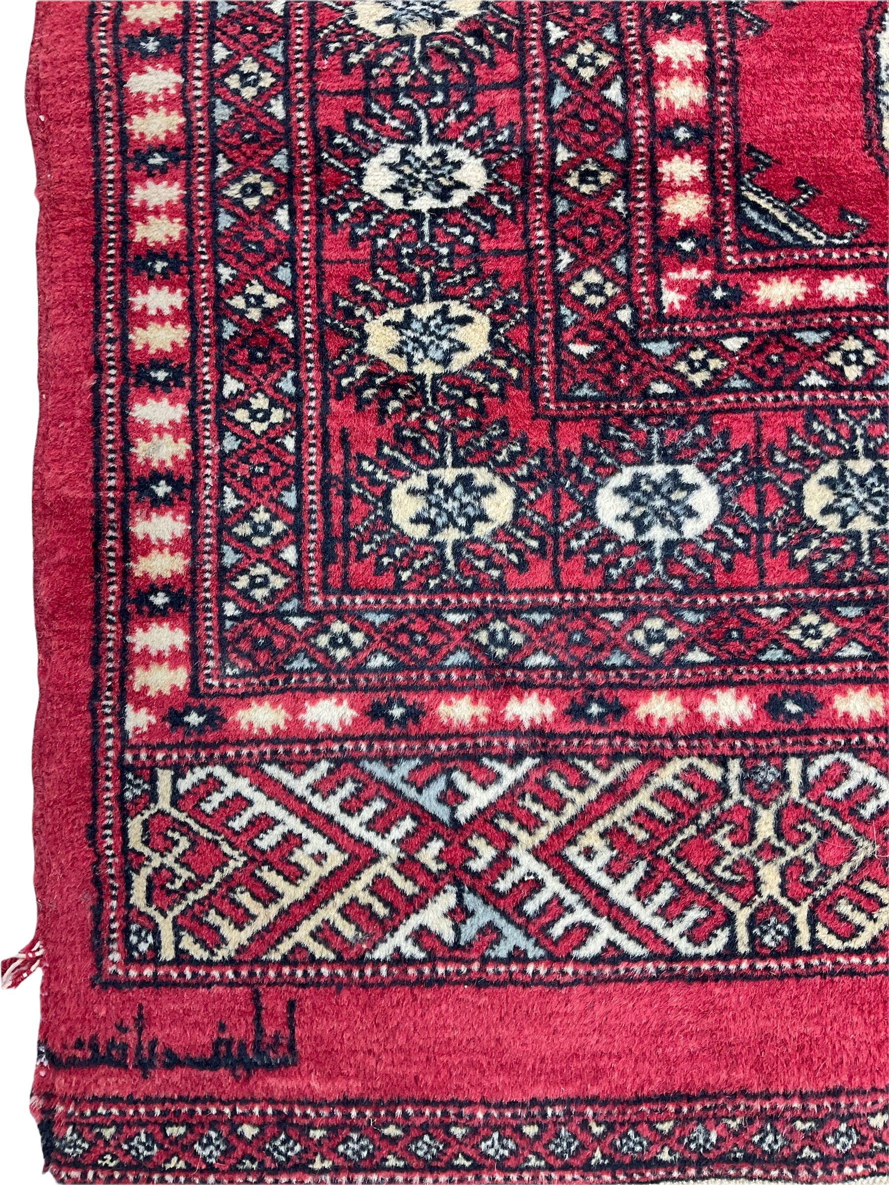 Turkmen Tekke Bokhara rug, red ground and decorated with Gul motifs, repeating multi-band border, signed on corners 