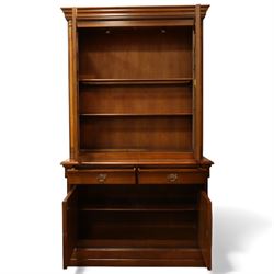 Edwardian mahogany bookcase cabinet, the moulded cornice above a pair of astragal glazed doors with gothic arched tracery, enclosing adjustable shelving, the projecting mid section fitted with two short drawers, over a pair of panelled cupboard doors with arched detailing, flanked by turned and pilasters, raised on a moulded plinth base