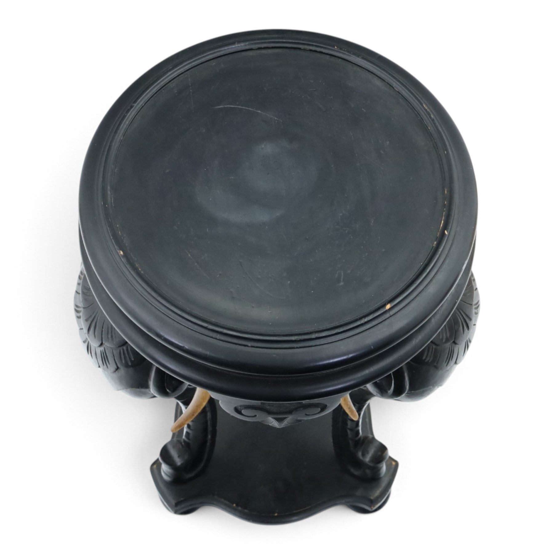 Elephant ebonised jardinière, moulded circular top raised on carved Elephant supports united by a shaped undertier