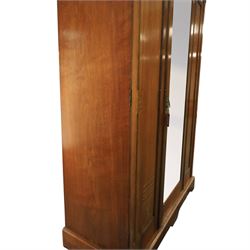 Aesthetic Movement walnut parcel gilt wardrobe, the crenellated top, above central mirrored door opening to reveal hanging space, four opened and two closed draws