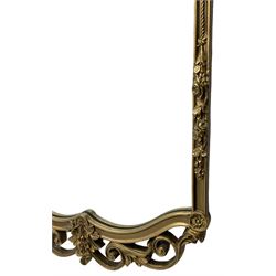 Gilt framed wall mirror, shaped cresting rail decorated with flower heads, the upright rails with further floral decoration over open scrolling foliate, plain mirror plate