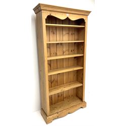 Solid pine open bookcase, projecting cornice above five adjustable shelves, shaped plinth base 
