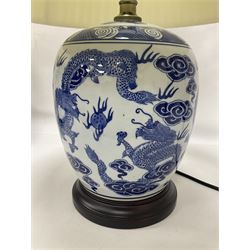 Pair of blue and white table lamps of ovoid form, each decorated with dragons chasing the flaming pearl amidst auspicious clouds, upon circular hardwood bases, excluding fitting H28cm
