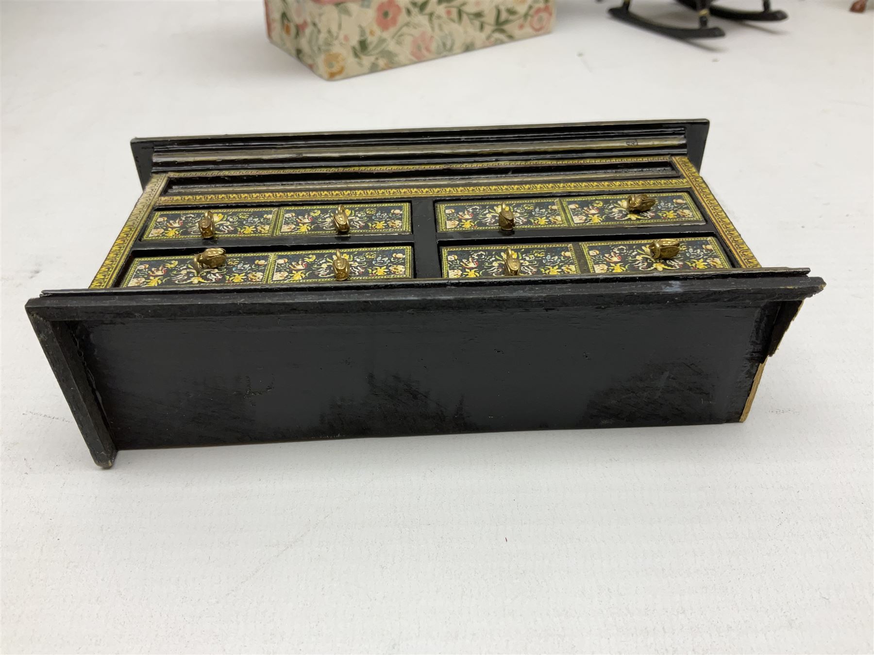 Collection of miniature dolls house furniture, to include five drawer chest painted with blossom, cream and gilt double door mirrored wardrobe, four piece lacquered style desk set, three piece suite, writing desk, wash stand, Knoll style sofa etc (14)