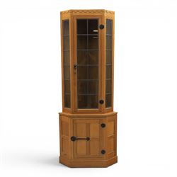 Mouseman - oak floor standing corner cabinet, scalloped cornice above a leaded glass cabinet, blackened metal hinges and latches, with carved mouse by the workshop of Robert Thompson of Kilburn