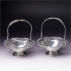  Pair of silver sweetmeat dishes with loop handles, pierced floral decoration and on a sho...