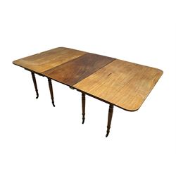 George III mahogany extending drop-leaf dining table, with additional leaf, rectangular top with rounded corners, raised on turned tapering supports with brass castors