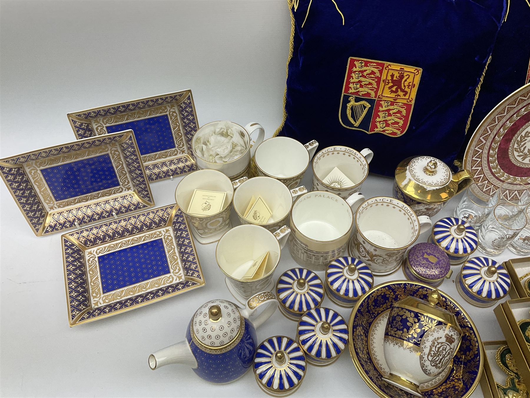 Commemorative ware Including five green and gold Highgrove limited edition hand embroidered tree decoration, a collection of ceramic ware from the royal collection including four cups and saucers, small teapot,    three trinket trays, five trinket pots with lids, eight tot glasses, three William Edwards Queens 80th cup, Hudson & Middleton hinged box etc. 
