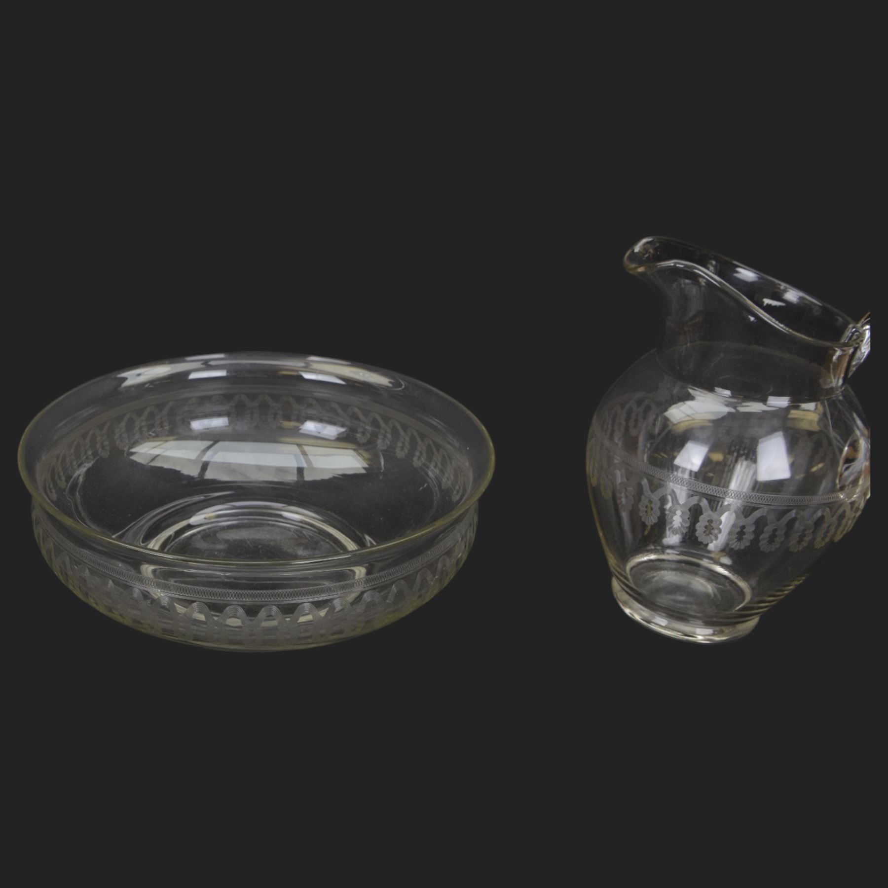 Edwardian glass wash jug and bowl, each engraved with looping border, jug H31.5cm, bowl D39.5cm