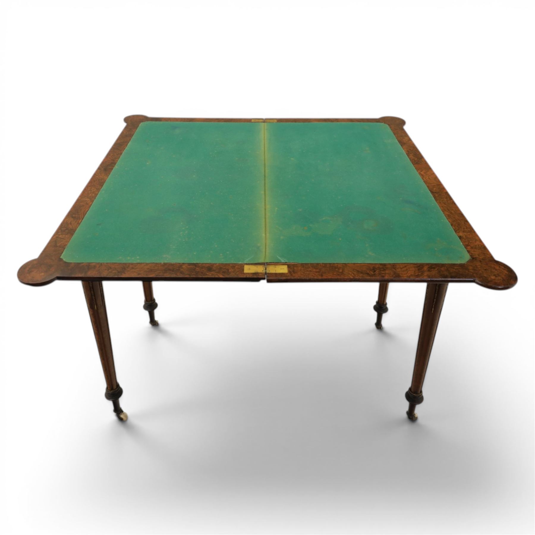 Victorian walnut card table, hinged rectangular moulded top with rounded corners and figured veneers, revealing a green baized lined interior, plain frieze with beaded lower edge, raised on ring turned tapering supports terminating in ceramic castors