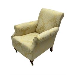 Traditionally shaped hardwood-framed armchair, rolled back and arms, upholstered in pale gold and cream damask fabric with repeating foliate pattern, on turned feet with brass cups and castors