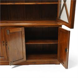 OKA - Glazed bookcase dark oark cabinet, the top with projecting cornice above astragal style glazed doors metal turned knobs, enclosing adjustable full length shelving, the lower half with two sets of twin cabinet doors housing fixed shelving, raised on a moulded plinth base  