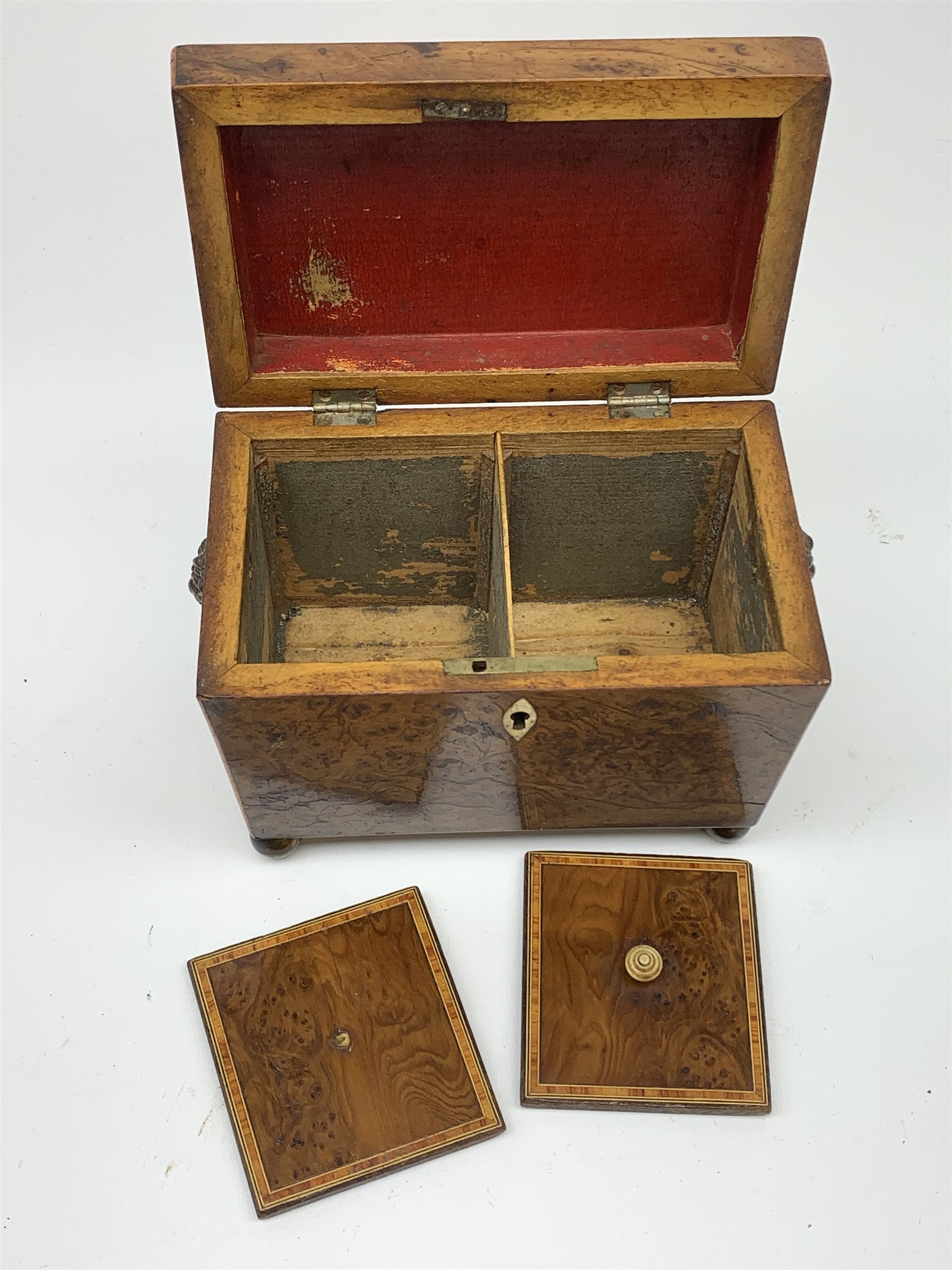 George III burr yew tea caddy, of sarcophagus form with lion mask ring handles and four brass ball feet, the hinged lid opening to reveal two compartments with cross-banded lids and traces of metallic paper lining, L19cm