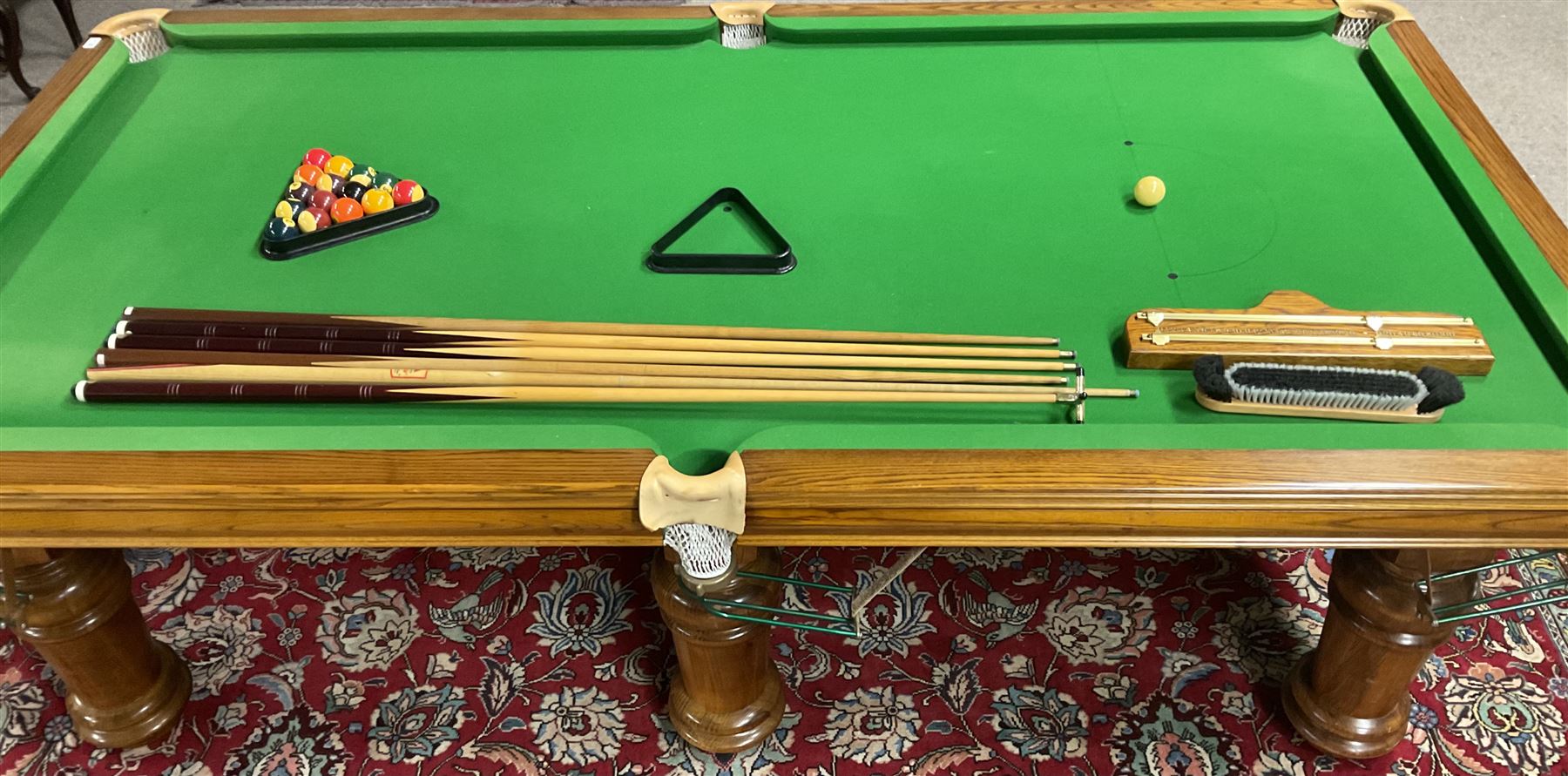 Late 20th century oak slate bed billiard table, on six turned column supports,  together with cues, ball set, baize brush, triangles and scoreboard 