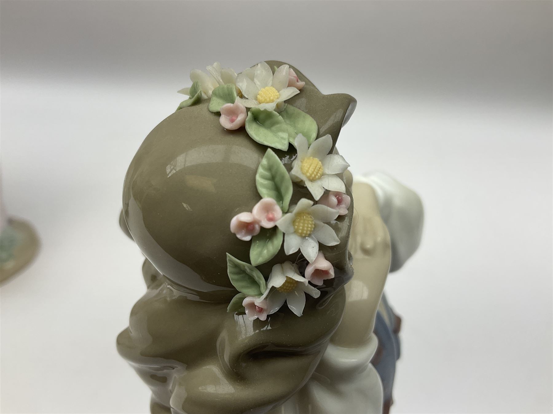 Three Lladro figures, comprising, Dreams of Summer Past no 6401, Spring Breeze no 4936 and Breezy Afternoon 5682 together with Lladro plaque Art Brings us Together no 7677, all in original boxes, largest example H35cm