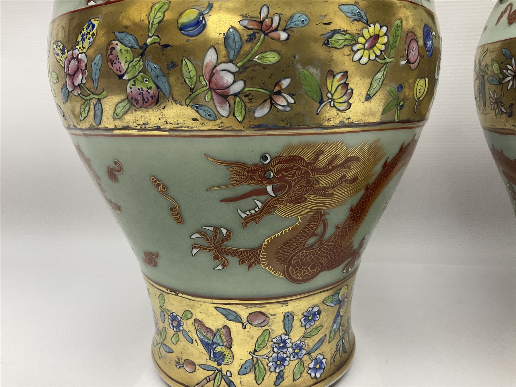 Pair of early 20th century Chinese vases decorated with dragons chasing a flaming pearl, with a gilt border of butterflies and floral sprigs, with Elephant head handles, H44cm 