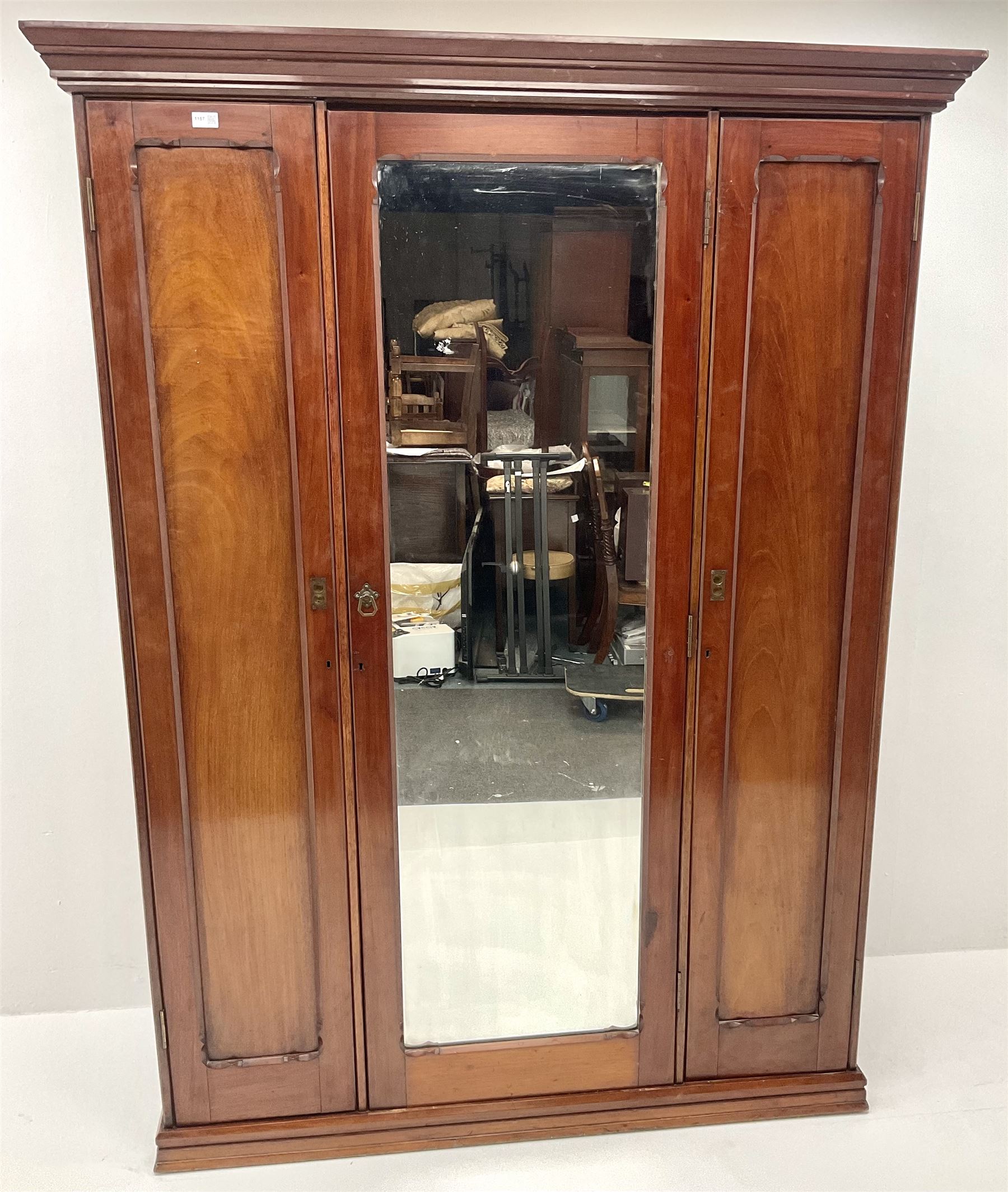 Victorian mahogany triple wardrobe, central mirrored door enclosing linen slides and two short and two long drawers flanked by two cupboards, plinth base