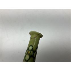 Three Minton Secessionist vases, with tube-lined stylised flower decoration, two upon a red ground and third upon a purple ground, all with printed mark to base 'Minton Ltd, No. 33', H13cm