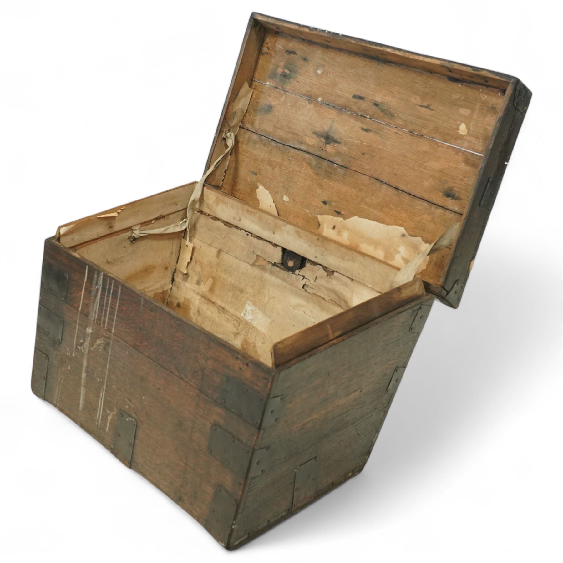 19th century metal bound ship’s trunk, of trapezoidal form with hinged lid, iron strapwork and corner reinforcements, remains of paper lining to interior