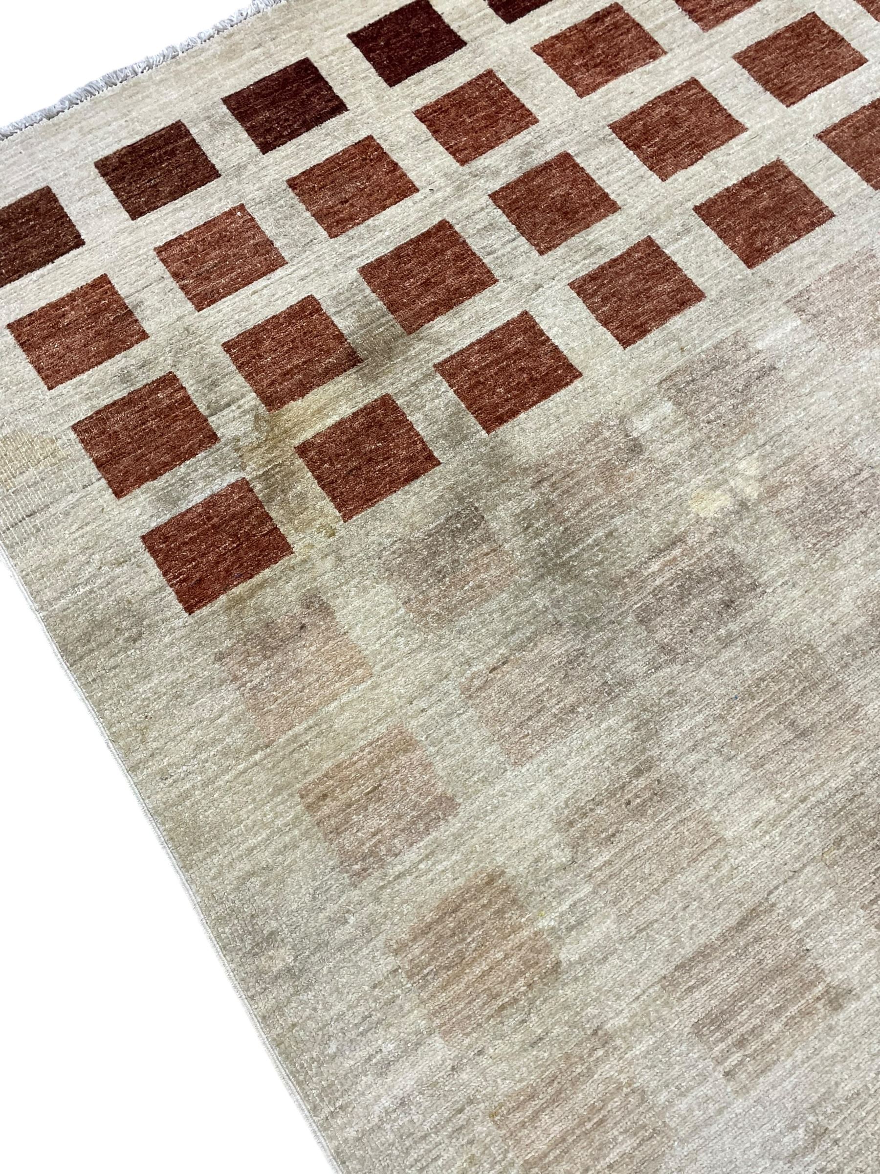 Contemporary camel ground woollen rug, decorated with gradient squares in shades of terracotta 