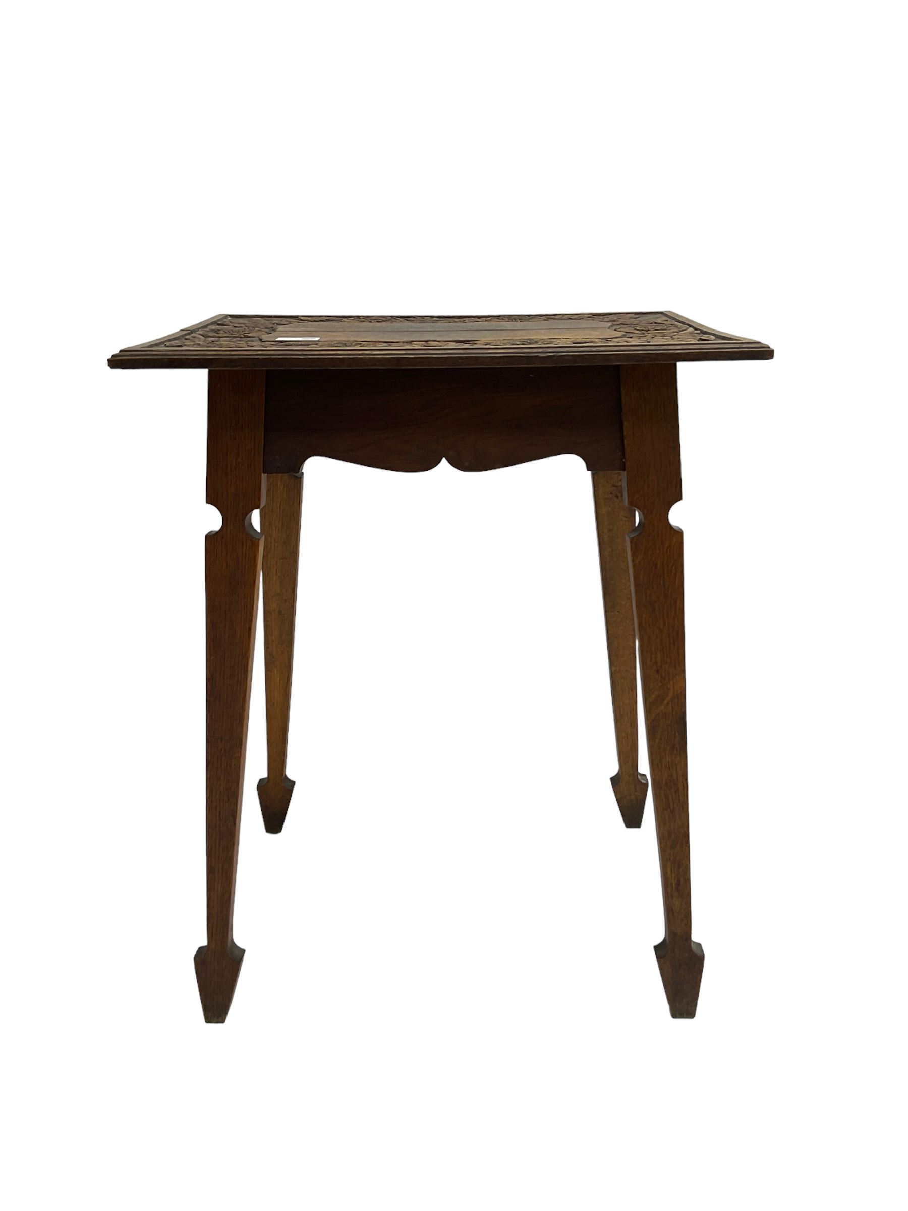 Arts & Crafts period oak occasional table, rectangular moulded top carved with trailing foliage and flower heads, on tapering supports with spade feet