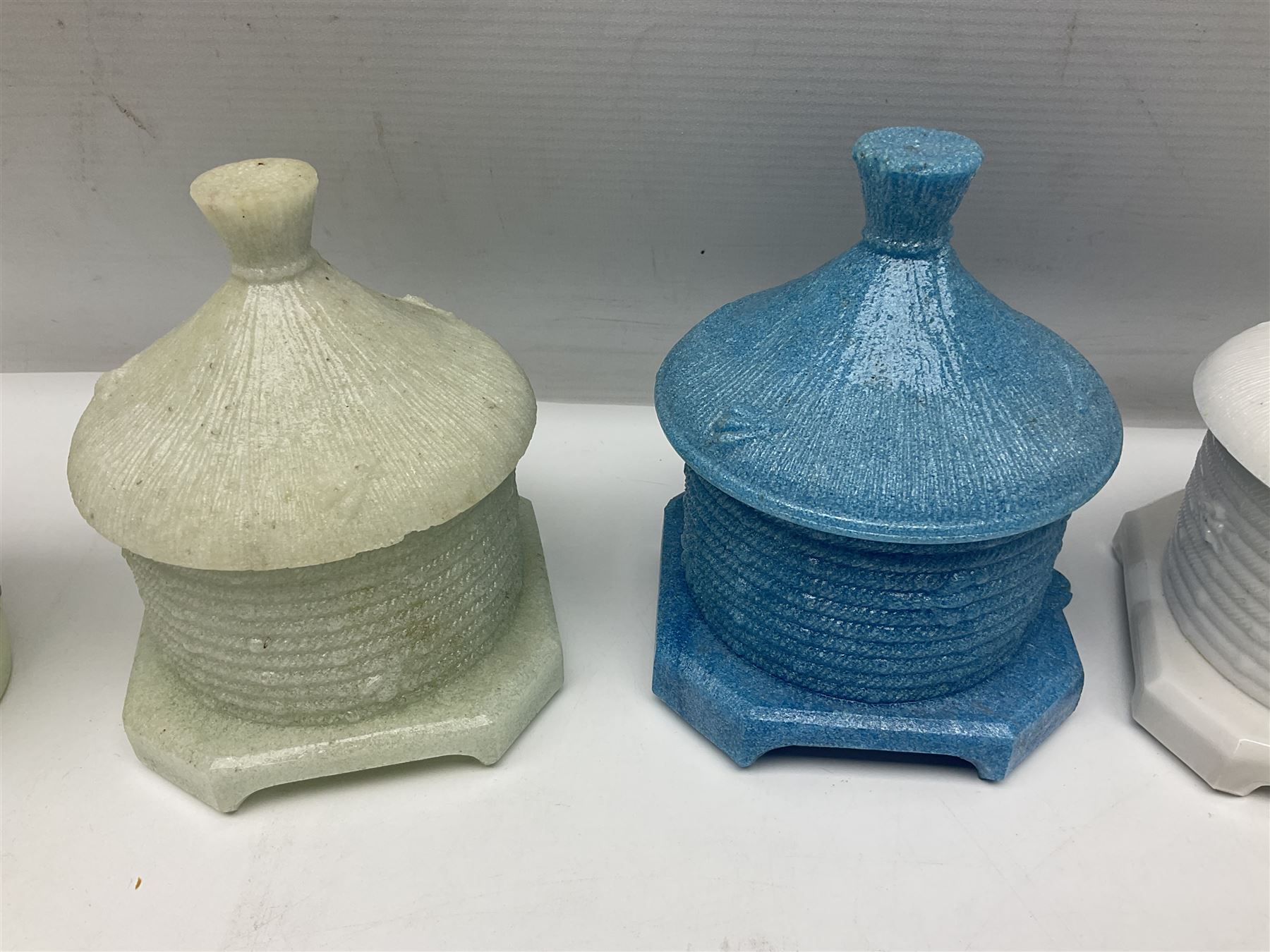 Collection of glass beehive honey pots, to include a blue slag example, milk glass, pink, green, etc together with four white metal examples (16) 