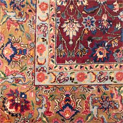 North East Persian Meshed hand-knotted carpet, rich red all-over field of finely decorated with dense scrolling floral sprays and palmettes and flowering vines, enclosed by a broad border in soft pastel tones, flanked by multiple guard borders, with cotton fringe ends  