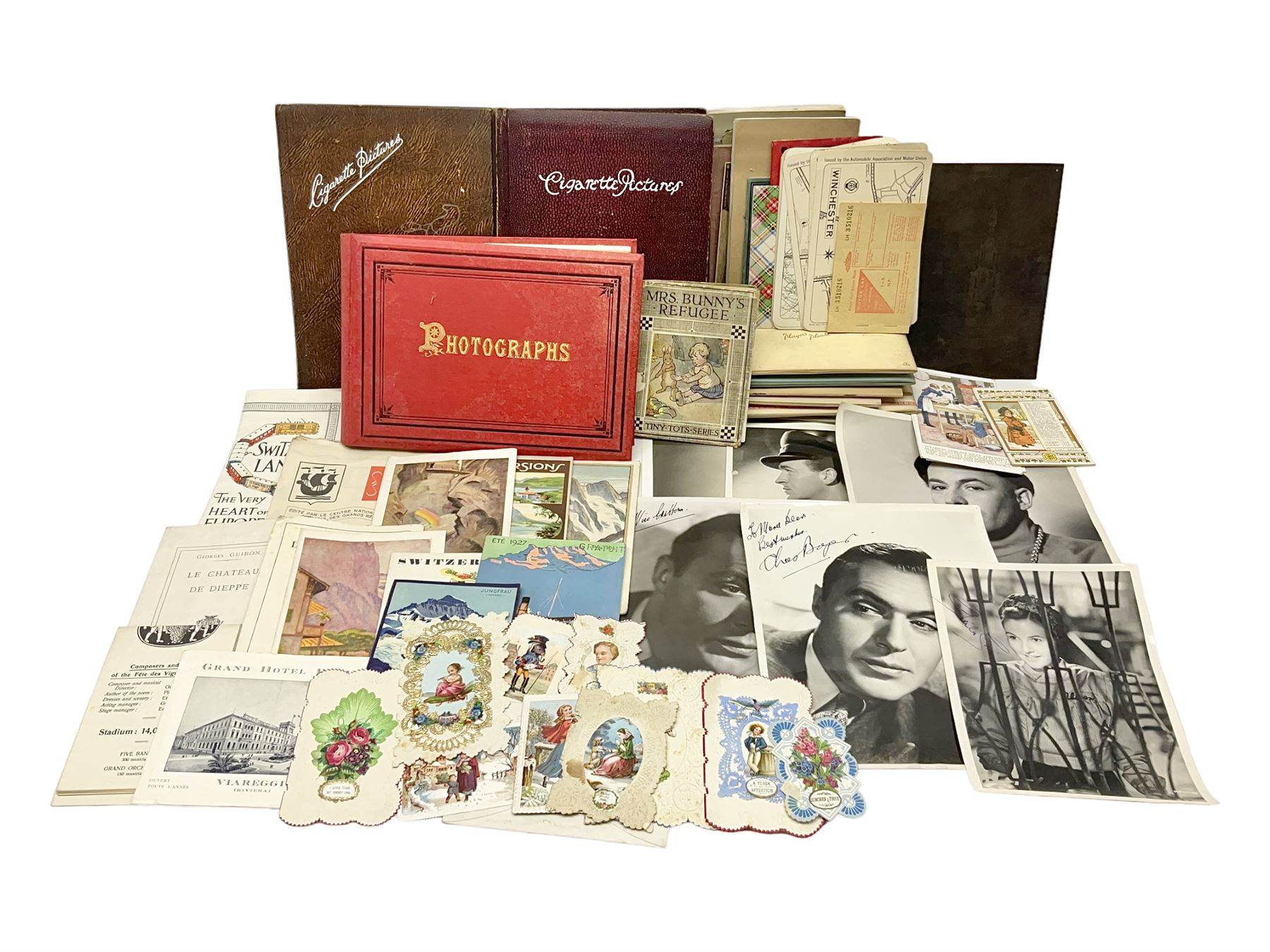 Early 20th century ephemera, to include signed photographs of Charles Boyer and Walter Pidgeon etc, a printed letter from Winston Churchill, two albums and a quantity of transfer books of Players and similar cigarette cards, including Boy Scout and Girl Guide Patrol Signs and Emblems and RAF Badges, a collection of greetings cards and postcards, a photograph album containing black and white photographs of Caius College Cambridge and guides and pamphlets on travelling Switzerland and the UK