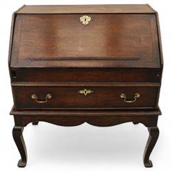 Early 18th century George I oak bureau on original stand, the fall front enclosing an arrangement of correspondence drawers and pigeonholes over central well, fitted with single long drawer below, the shaped apron over cabriole supports with pad feet