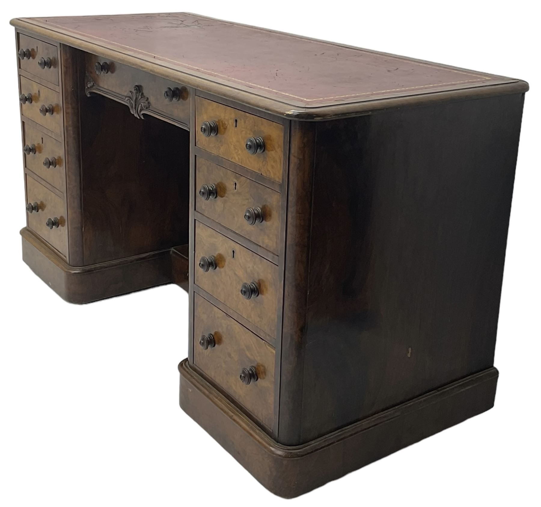 Victorian figured walnut kneehole desk, moulded rectangular top with inset leather writing surface, fitted with nine drawers, the central frieze drawer with carved curled foliage mount, on moulded plinth base,