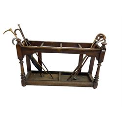 Edwardian oak hallway stick and umbrella stand, four divisions on turned supports, with metal tray liners and various sticks