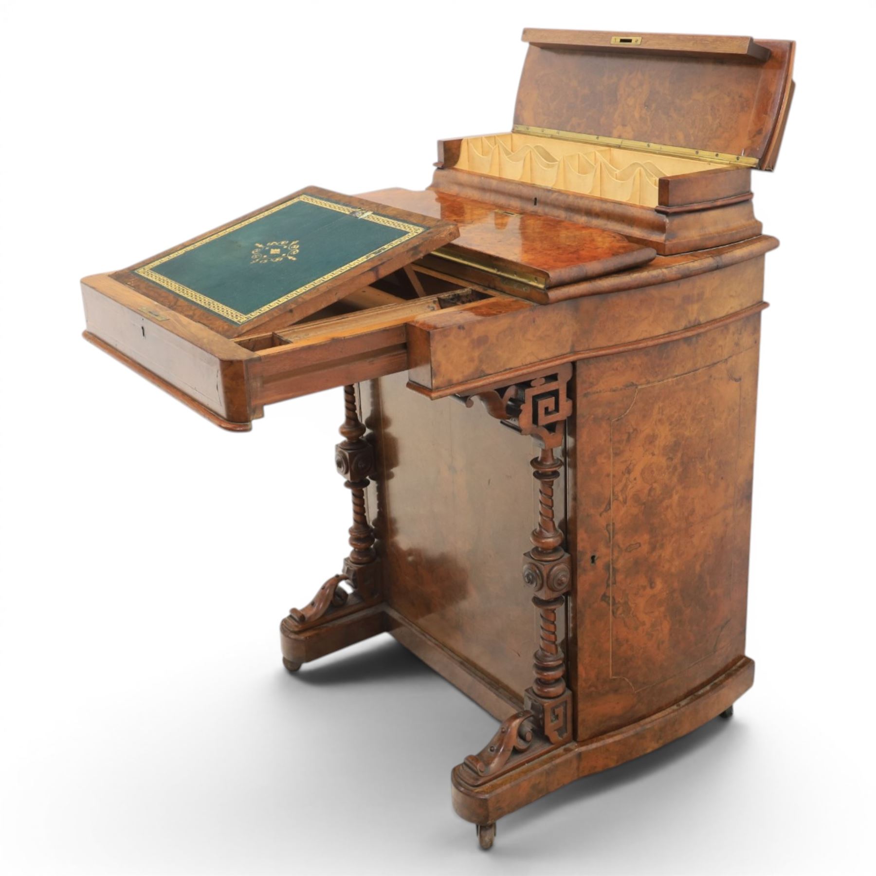 Victorian burr walnut Davenport, with hinged stationary top and slope, pull out writing surface with tooled green leather inset top, carved and turned front supports, flanked by two cupboard doors, raised on castors 