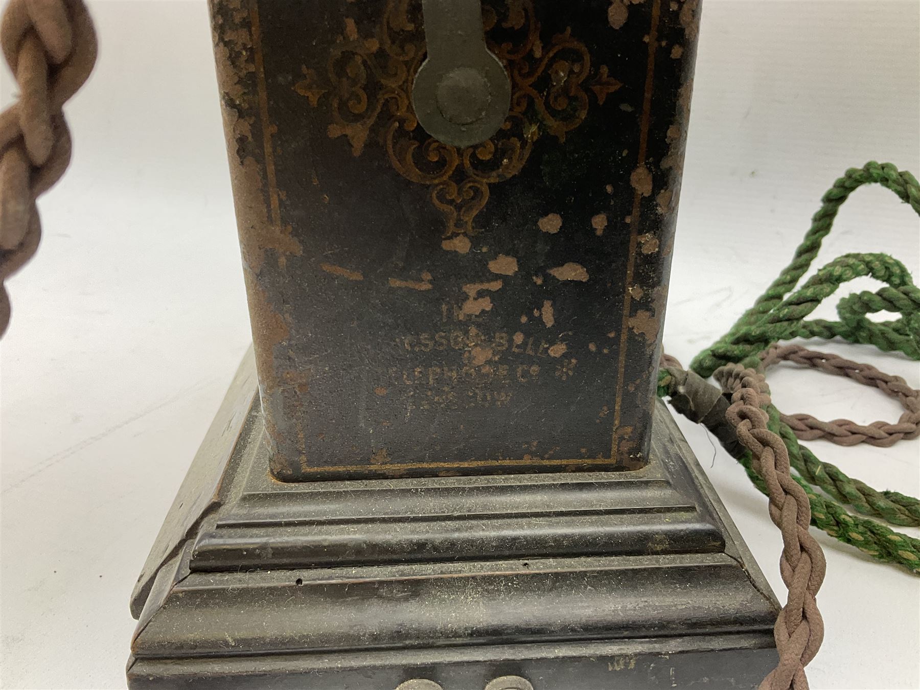 Early 20th century Danish desk telephone inscribed The Ericsson Bell Telephone Co. Glasgow to one side and Aktieselskabet Electrisk Bureau Kristiansand to the other, ebonised wooden top with handset on brass cradle. black japanned tin centre section bearing Hull Corporation Telephones Department crest, side cranking handle and ebonised wooden base H30cm  