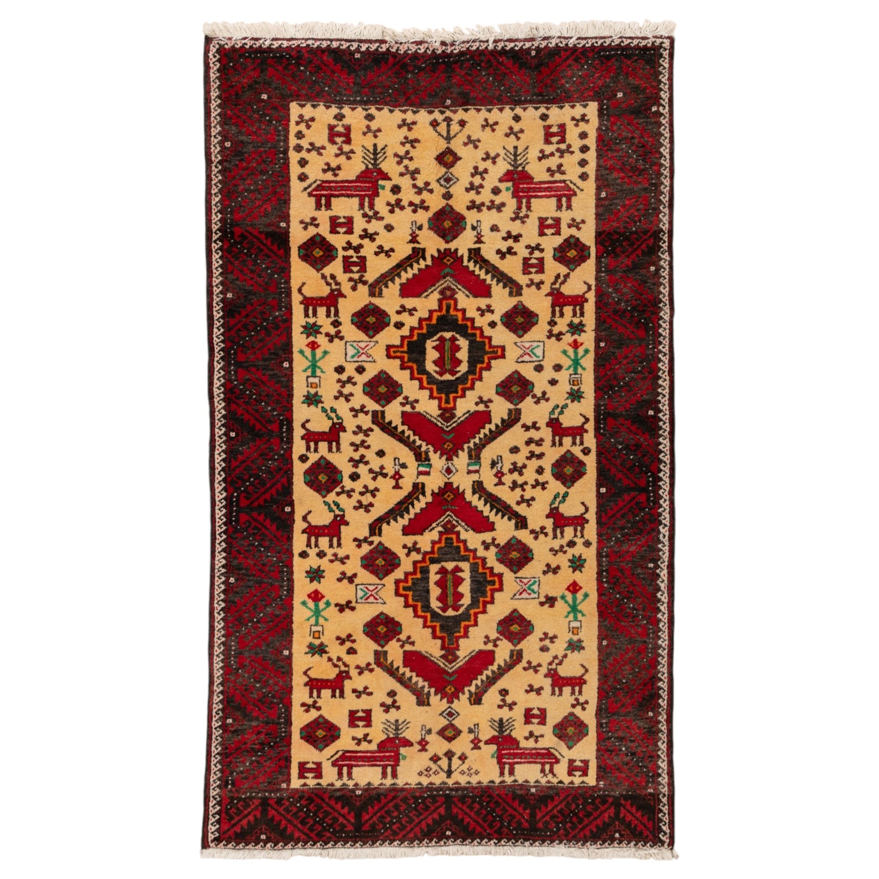 North East Persian Meshed Baluch rug, the ivory field decorated with two stepped diamond medallions and angular red motifs, interspersed with stylised horned animals, birds, flowerheads and geometric devices, enclosed by a dark brown border of repeating red serrated leaves and narrow ivory guard bands
