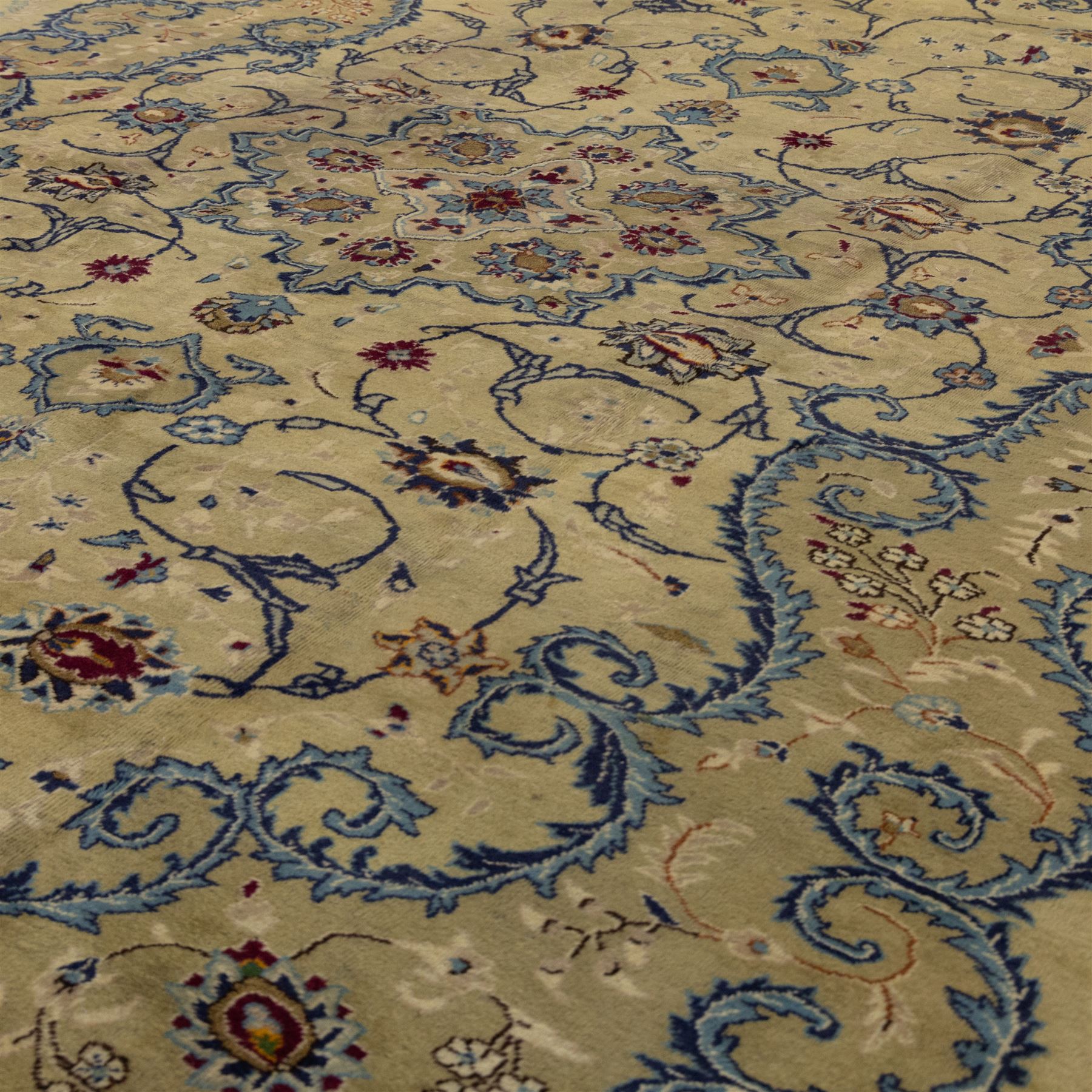 Central Persian Kashan hand-knotted carpet, ivory field with central shaped medallion, surrounded by intricate arrangement of scrolling vine and floral motifs in  pale blue tones, within conforming spandrels and matching border, cotton fringe ends  