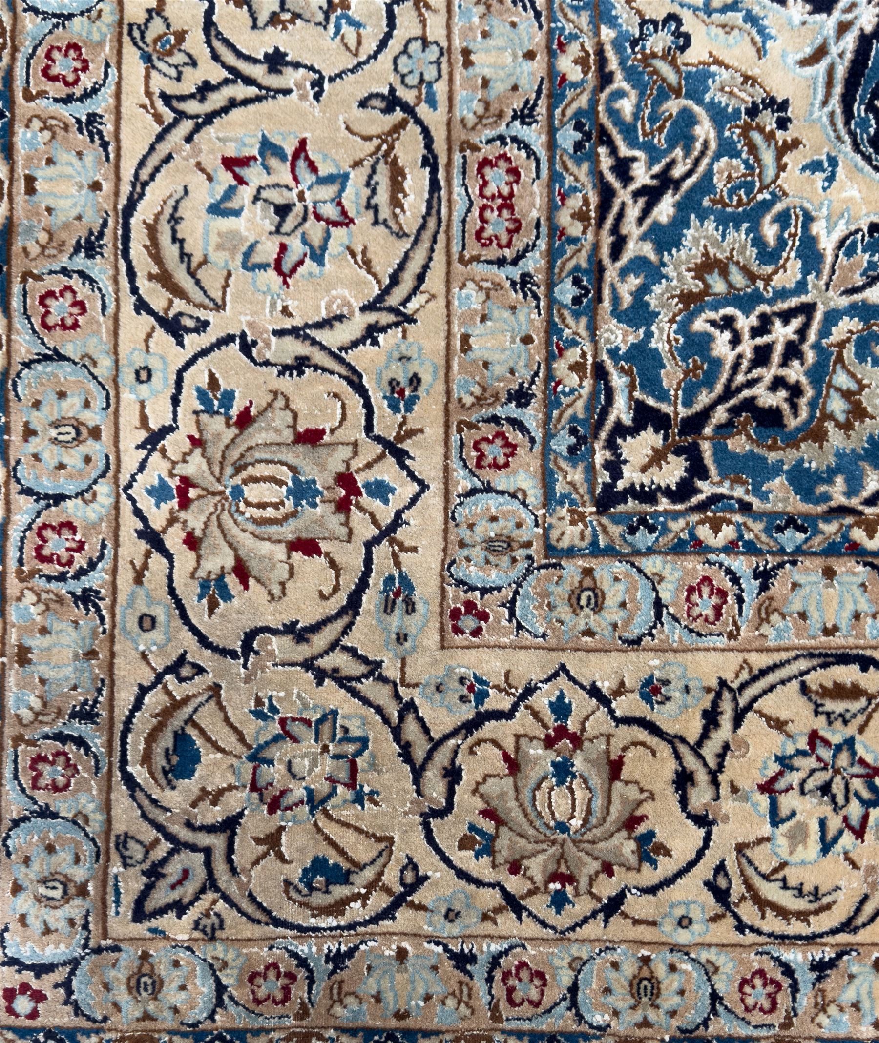 Central Persian Nain carpet, the deep blue field with finely drawn scrolling palmettes and flowering vines around a central ivory and sky blue rosette medallion, enclosed by an ivory border of interlaced floral arabesques and lotus forms between multiple guard stripes, from the region of Nain