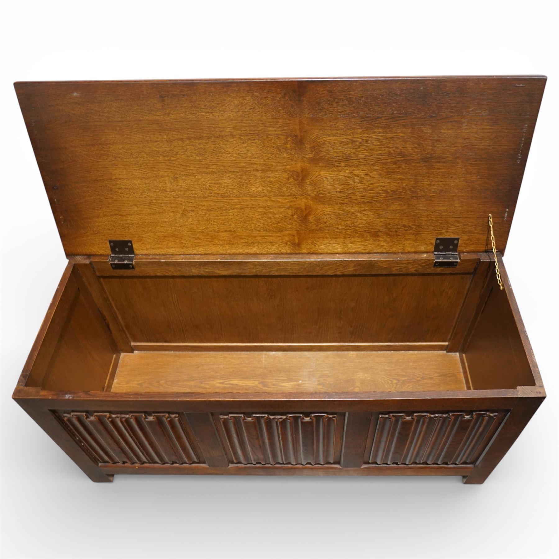 Late 20th century oak linenfold blanket box, with hinged rectangular top opening to a plain interior, the front carved with three linenfold panels, plain panelled sides, raised on stile supports