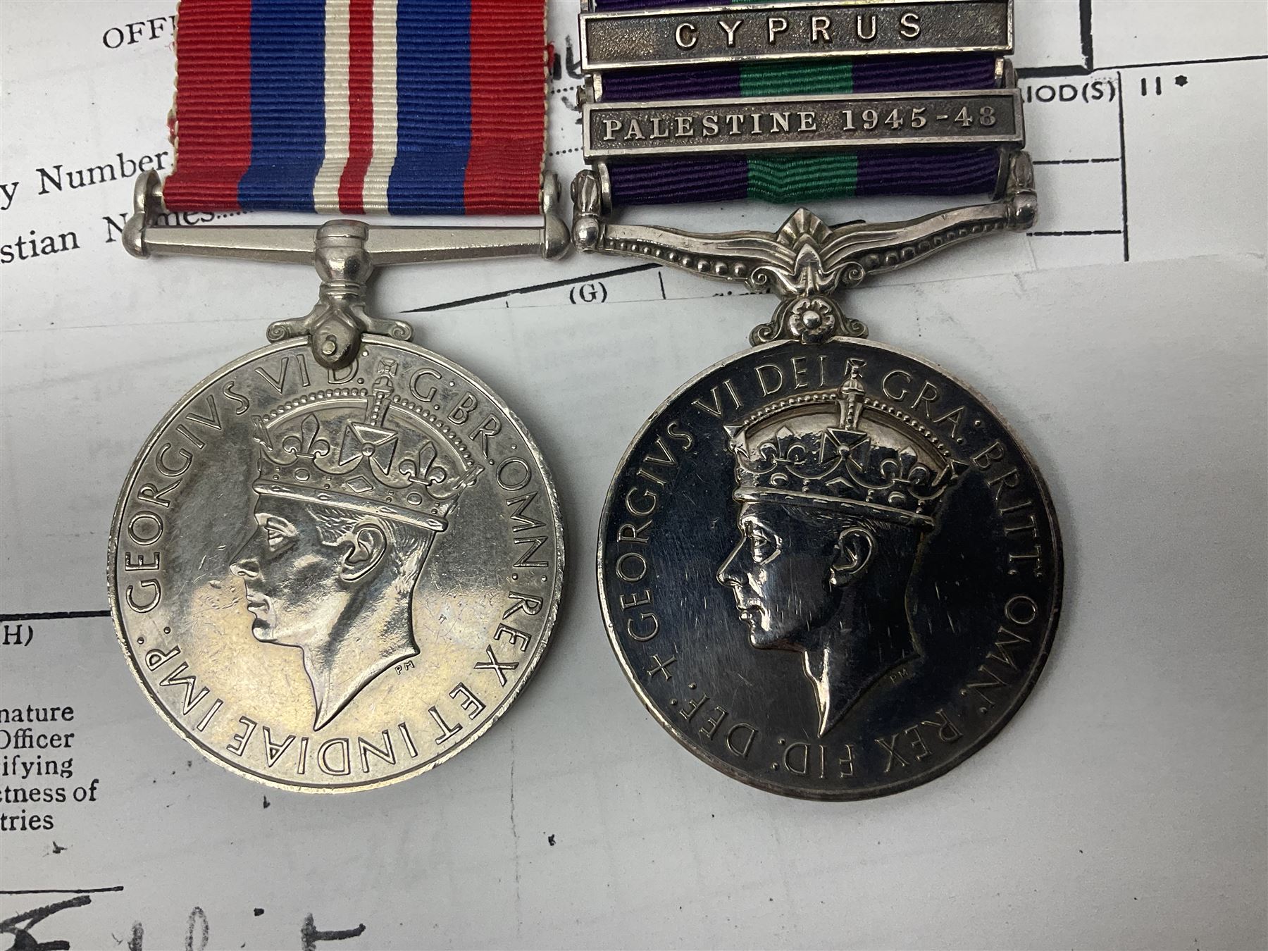 George VI General Service Medal with two clasps for Palestine 1945-48 and Cyprus and MID oak leaf awarded to 14887162 Sjt. C.F.A. Lloyd R.A.M.C. together with WW2 War Medal 1939-1945; both with ribbons; and quantity of photocopied research material including Army Records and London Gazette