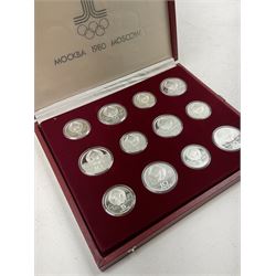 Russian 1980 Moscow Olympic Games silver twenty eight coin set, housed in dated red case and four other coins relating to the Olympics, housed in dated black case